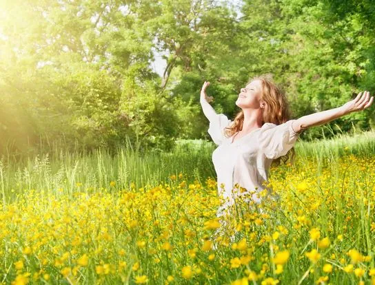 Mujer en la naturaleza liberada de energías negativas